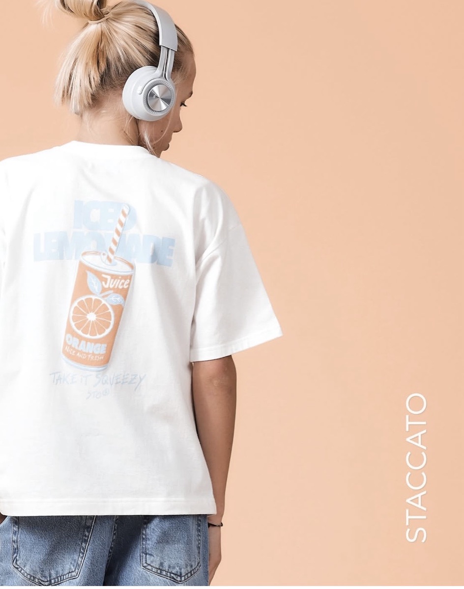 A girl seen from behind in a white oversized T-shirt with a soft-hand printed back graphic